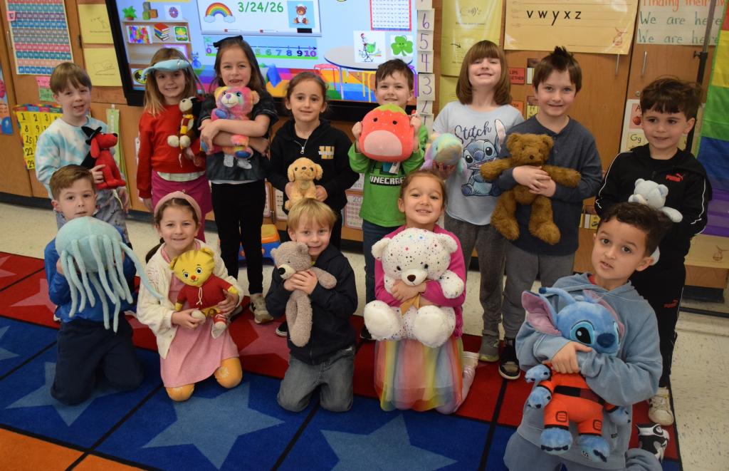 kids sitting on floor holding stuffed animals